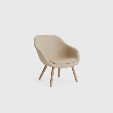A gray About A Lounge Chair with shaped armrests and round wooden legs.
