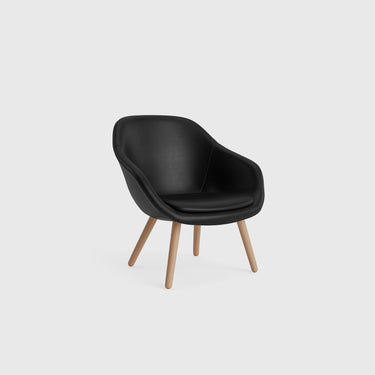 A gray About A Lounge Chair with shaped armrests and round wooden legs.
