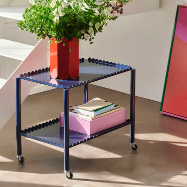 A blue Arcs Trolley Low with vertical arcs forming shelves, supported by slim legs on castors.