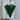Green umbrella leaning against a white radiator in a room.