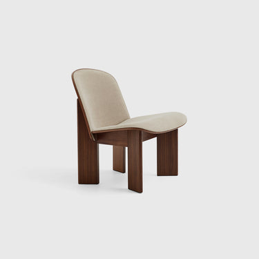 A contemporary upholstered lounge chair with a walnut frame, beige seat cushion, and angled legs.