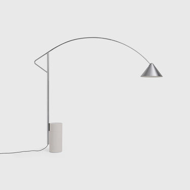 A modern floor lamp with a slim curved silver metal arm, a cone-shaped shade, and a cylindrical off-white base, shown against a light gray background.