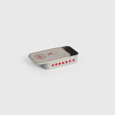 Rectangular open tin box with red star patterns on a light grey background