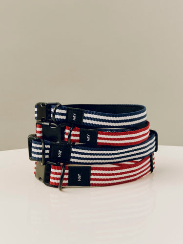 Set of striped dog collars with 'HAY' branding on a light surface.