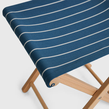 Chair with a blue and white striped cushion on a light gray background