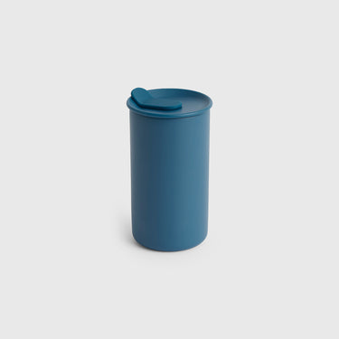 Blue tumbler with a lid on a light gray background