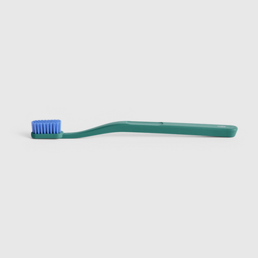 Green toothbrush with blue bristles on a white background