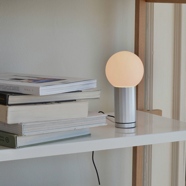 Hay Turn On Lamp in silver aluminium sitting on Pier System shelf
