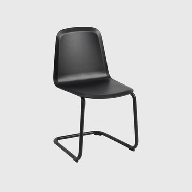 A modern black molded plastic chair with a cantilevered metal base, shown against a solid light gray background.