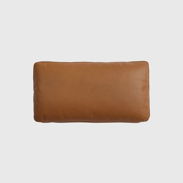 A rectangular tan leather lumbar pillow with a smooth texture, shown from a top-down view on a light gray background.