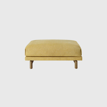 A modern rectangular ottoman with a light yellow textured fabric upholstery and light natural wood legs, shown against a solid light gray background.