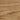 A close-up texture of light brown wood grain with natural wavy patterns and variations in tone.