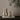 Two ceramic vases with black stripes on a stack of books against a beige wall.
