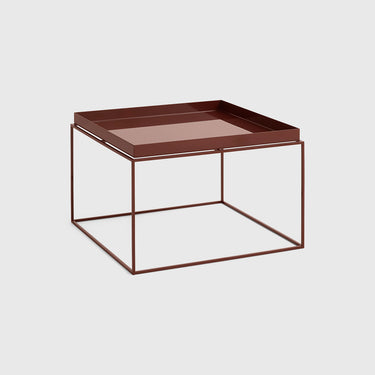 A modern square side table featuring a dark brown tray on top of a minimalist open cube wire frame base, set against a solid light gray background.