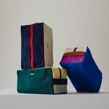 Colorful bags with 'HAY' branding on a light gray background