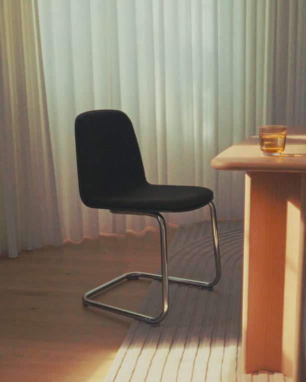 Video of a fully upholstered chair with a chrome cantilever base