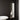 Minimalist wall mirror on a black wall in a bathroom.